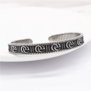 Détail du bracelet plume d'aigle argenté vintage avec texture gothique et gravures
