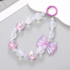 Pink beaded phone charm with bow and heart charms on a sleek grey background