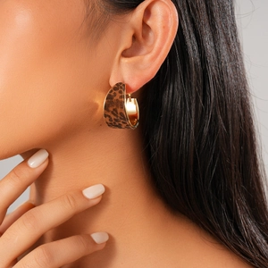Close-up of leopard print flocked C-shaped hoop earring with a polished gold interior
