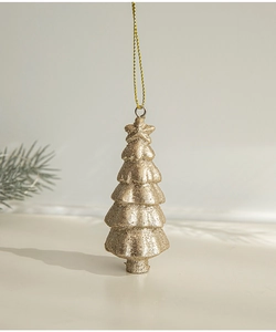 Champagne gold Christmas tree pendant with glitter coating hanging in a minimalist setting