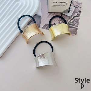 Detailed view of elastic hair ties with textured metal geometric accents in gold and silver