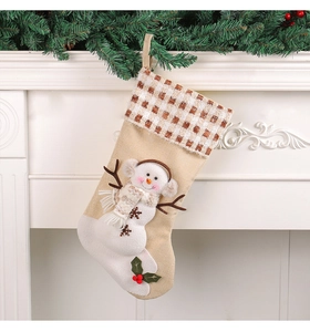 Detail of beige Christmas stocking featuring a 3D snowman with plaid trim and holly decor