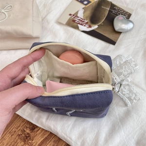 Detail view of large capacity purple bow cosmetic bag with white lining and inner compartments