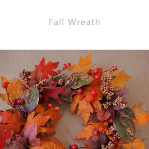 Close-up of autumn wreath with maple leaves and berries on wooden floor background