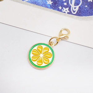 Macro shot of lemon slice enamel charm with gold-plated lobster clasp and metal details