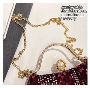 Detail of burgundy sequin evening bag with gold metal handle and large pearl clasp