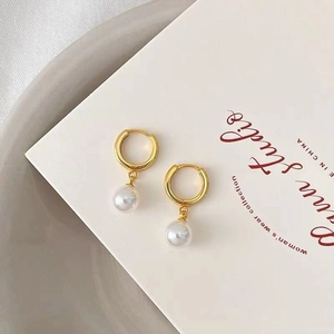 Elegant gold hoop earrings with white pearl drops for women in minimalist luxury style