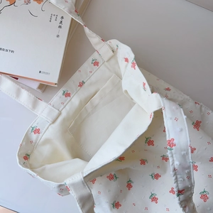 Detail of floral cotton tote bag showing the interior pocket and red flower pattern