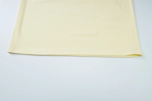 Detailed view of pale yellow hemline featuring precision double-needle stitching on knit fabric