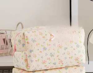Dettaglio della borsa da trucco a fiori in velluto a coste con zip rosa