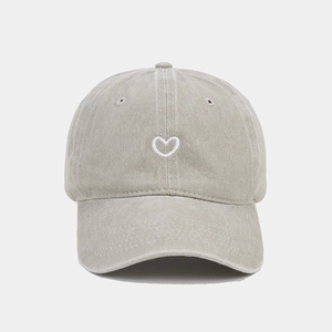 Detail of vintage washed cotton baseball cap featuring minimalist heart embroidery