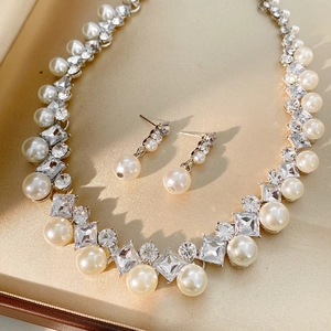 Close-up of elegant silver pearl and zircon necklace and earring set in a display box