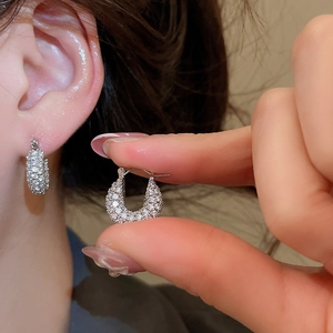 Macro shot of silver U-shaped earrings featuring dense micro-pave cubic zirconia inlay