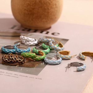 Detail of enamel C-shaped grid earrings in candy colors on minimalist background