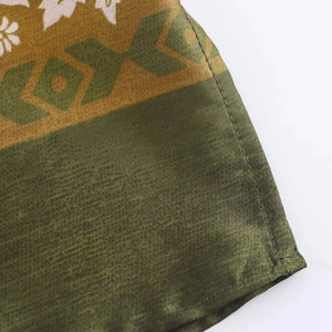 Détail du tissu satiné soyeux avec imprimé vert et couture de finition de haute qualité