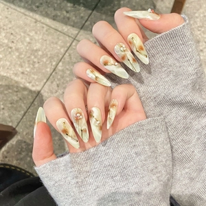 Hand-painted press-on nails with marble texture, gold foil, and 3D pearl decorations