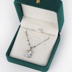 Detail of a square cut clear crystal pendant set in a luxury velvet green jewelry box