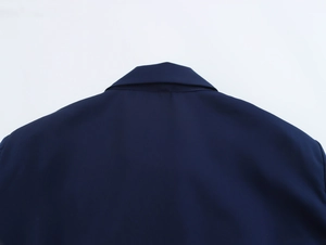 Detail view of navy blue satin dress neckline with delicate pleats and fabric texture