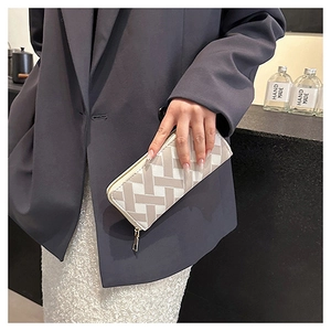 Close-up of a long wallet with grey and white geometric woven pattern in a street style view