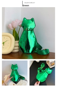 Detail of green patent leather cat-shaped bag with glossy finish and wide nylon strap