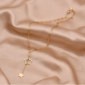 Gold paperclip chain necklace featuring double star pendants on silk background