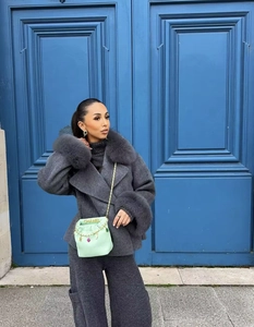 Détails d'un manteau en laine gris foncé avec fourrure et un sac à main vert menthe chic