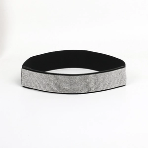 Close-up of sparkling silver rhinestones on a wide black elastic fashion waist belt
