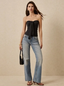 Sexy zwarte off-shoulder bandeau top met strik en blauwe jeans met wijde pijpen