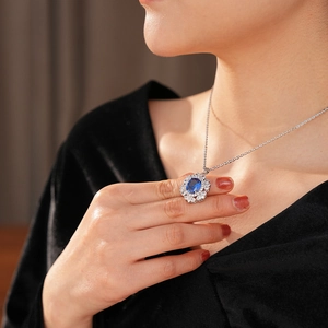 Dettaglio di una collana vintage in argento con ciondolo ovale in pietra blu e halo di diamanti