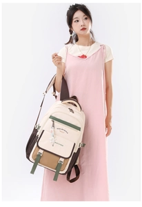 Vue détaillée du sac à dos crème et marron avec accents verts porté par un mannequin