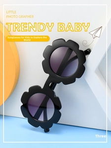 Detail of flower-shaped kids sunglasses with black frame and purple gradient lenses