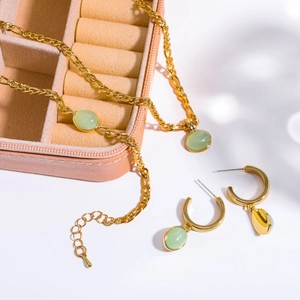 Detail of green aventurine necklace and earrings set with 18K gold plated Figaro chain