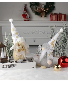 Christmas faceless gnome dolls with gold and grey hats on a festive mantelpiece