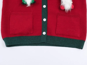 Détail du cardigan de Noël rouge montrant l'ourlet côtelé vert et les boutons blancs