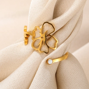 Detailed view of a gold floral ring with zircon on elegant champagne silk fabric