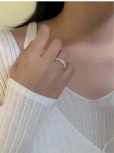 Close-up of elegant pearl ring with a central zircon stone on silver-tone band