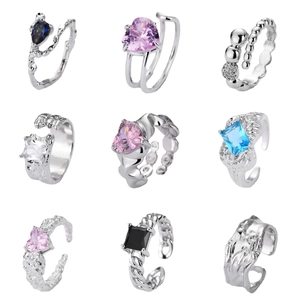 Collection of nine irregular silver open rings with colorful zircon gemstones in grid layout