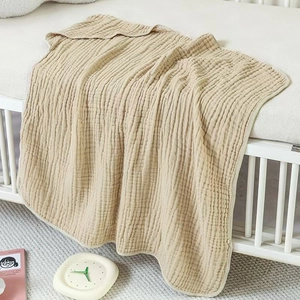 Beige 6-layer muslin cotton hooded towel for babies shown hanging on a railing