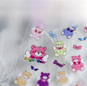 Close-up of cute Angel Bear nail art stickers in various pastel macaron colors