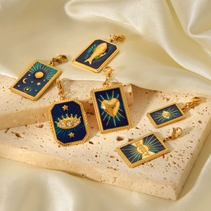 Detail of six gold-plated charms with navy blue enamel and celestial sun moon patterns