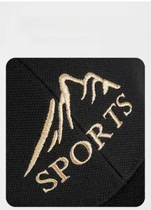 Close-up of golden mountain embroidery and sports text on black mesh baseball cap