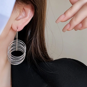 Close-up of silver multilayer hoop earrings worn by a model for a stylish look