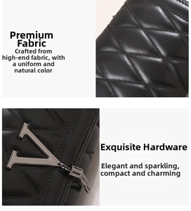 Close-up of black quilted leather texture with V-shaped metal hardware and chain tassels