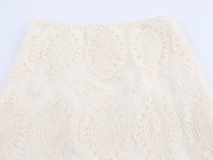 Dettaglio elegante gonna in pizzo beige con ricami floreali e trama in vita rifinita