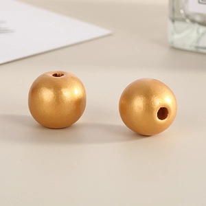 Macro shot of 16mm polished gold wooden beads with smooth finish and central drill holes
