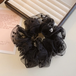Détail d'un chouchou en organza noir avec motifs cœurs floqués et texture voilée