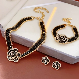 Detail of luxury jewelry set with black camellia flowers and sparkling rhinestones