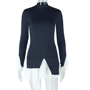 Detail of high neck long sleeve dress with white ruffled cuffs and asymmetrical hemline