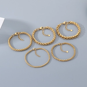 Détail de cinq chaînes de blé dorées avec maillons d'extension et pendentifs ronds