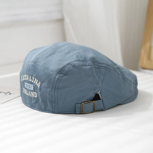 Detailed embroidery of 1963 Catalina Island on a navy blue cotton flat cap with metal buckle